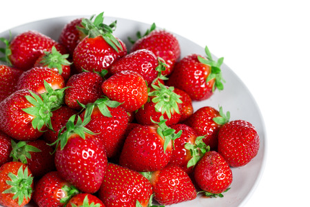 Strawberries in a bowl isolated on white backgroundの写真素材