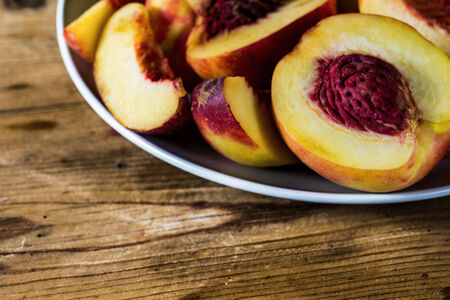 Organic peaches on a rustic tableの写真素材