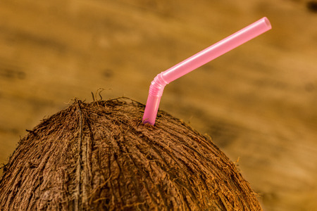 Coconut close-up with straw on a background of rustic tableの写真素材