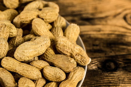 Plate of peanuts on a rustic wooden tableの写真素材