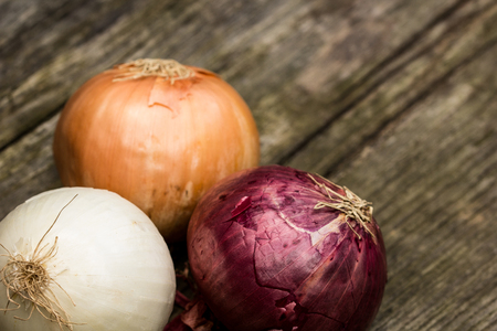 Onions of different qualities on a wooden benchの写真素材