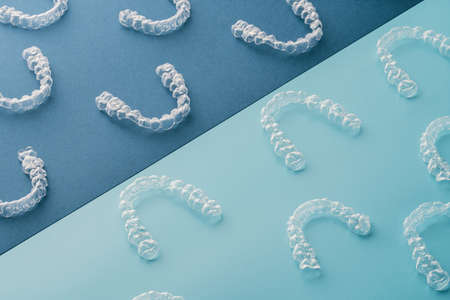 Transparent and invisible dental aligner for orthodontic treatment on blue and black background