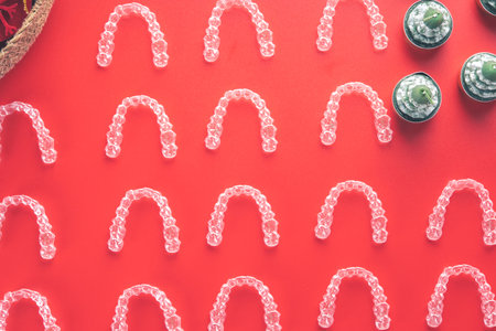 Many invisible dental aligners or clear aligners on red background for christmas. Aesthetic orthodontic treatment that the dentist does in the dental clinic.の写真素材