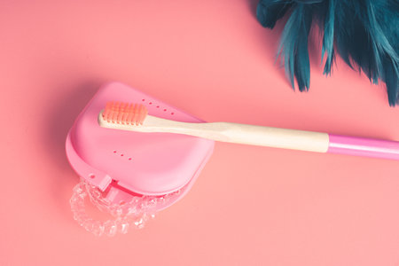 Many invisible dental aligners or transparent aligners on red background. Aesthetic orthodontic treatment that the dentist does in the dental clinic.の写真素材