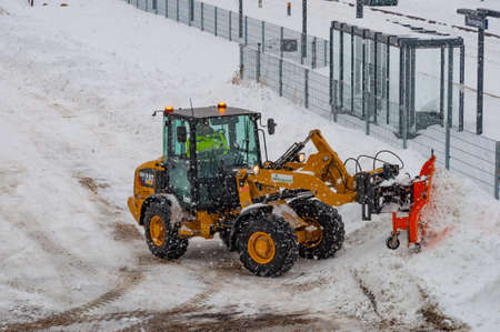 Vordingborg Denmark - February 3. 2018: Caterpillar wheel loader with a snowplow plowing snow during a blizzardのeditorial素材
