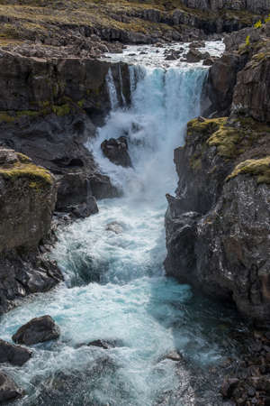 Waterfall in Fossa river in Berufjordur in East Icelandの写真素材