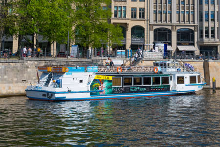 Berlin Germany - April 20. 2018: Canal tour boat moored to pier in River Spreeのeditorial素材