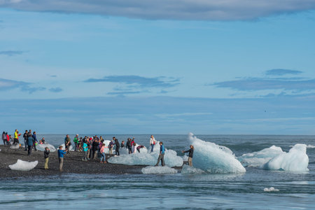 Jokulsarlon Iceland - August 18. 2018: Tourist looking at ice at Diamond beach in Iceland
