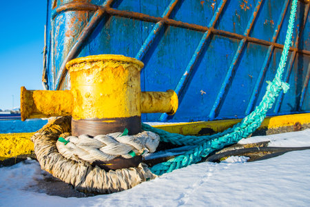 rope from a ship around a bollard on the pier of the port