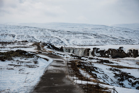 Path towards Godafoss waterfall on a snowy winter day