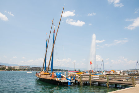 Geneva Switzerland, June 26. 2023: boats at the pier of Geneva lake with the fountain in the...