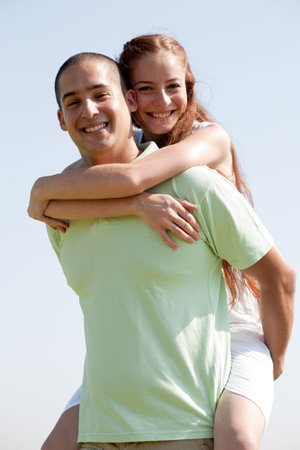 Happy Young Man Piggybacking His Girlfriend