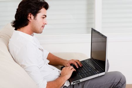 young guy doing work in sofa working at homeの写真素材