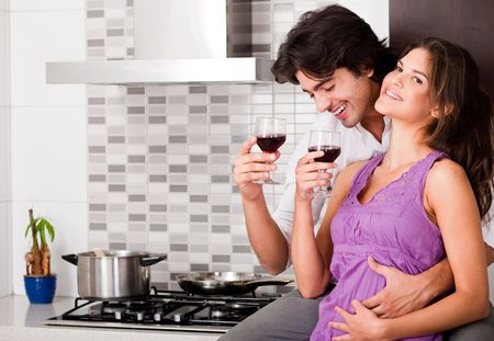 honeymoon couple drinking wine in kitchenの写真素材
