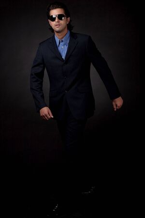 young business man walking in isolated black backroundの写真素材