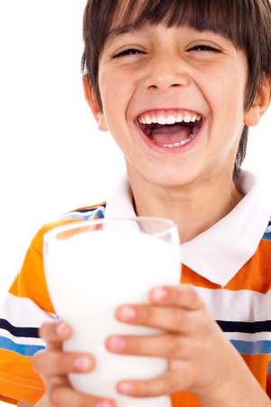 Smiling young boy holding a glass of milk over a isolated white backgroundの写真素材