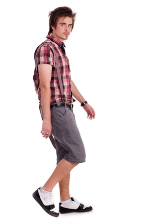 Casual handsome young guy in walking posture isolated on white backgroundの写真素材