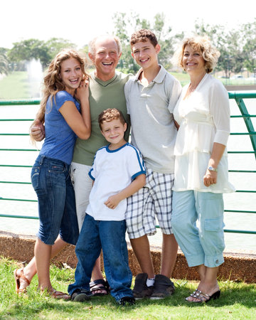 Happy family posing infront of the lake on a sunny day