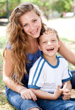 Close-up shot of a mother posing with a cute little boy in the parkの写真素材