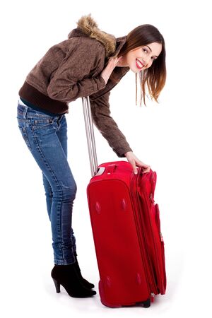 young lady posing while unzipping her travel bagの写真素材