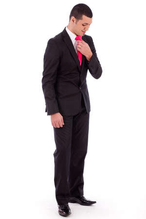 Business man bending his head down to fit his necktie on a isolated white backgroundの写真素材