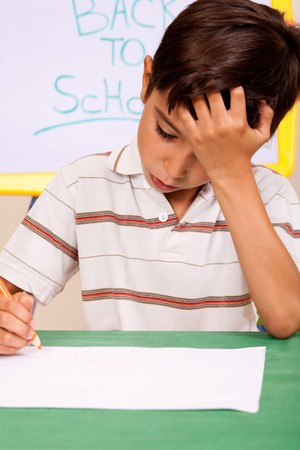 little boy with hand on his head, having  trouble with homeworkの写真素材