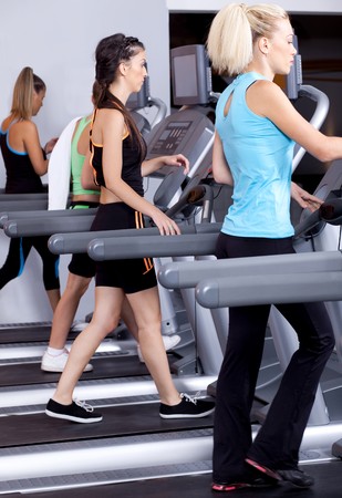 image of fit ladies jogging on trademillの写真素材