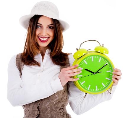 Portrait of stylish lady holding alarm clock on an isolated backgroundの写真素材