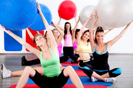 image of people doing stretching exercise with fitness ballsの写真素材