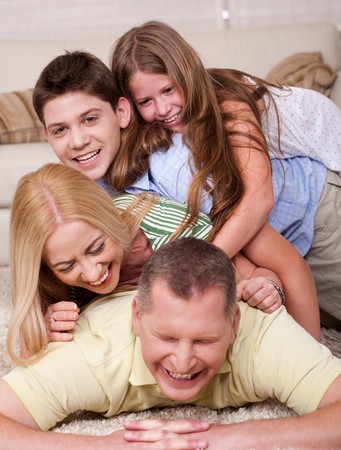 Full portrait of a happy family lying on bed and having great timeの写真素材