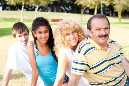 Portrait of family relaxing in park during their weekend.の写真素材