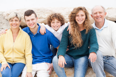 Happy family sitting on rock on summer vacation