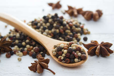 pepper in wooden spoon/ mixture of red pepper, black pepper, white pepper, green pepperの写真素材