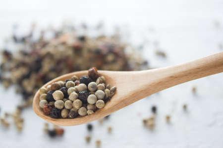 pepper in wooden spoon/ mixture of red pepper, black pepper, white pepper, green pepperの写真素材