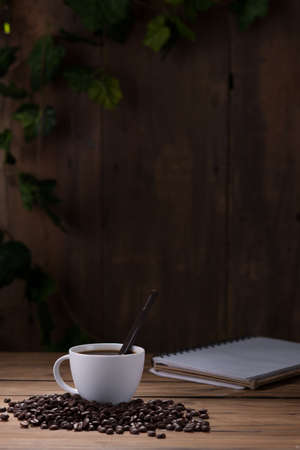 Coffee cup and coffee beans on wooden backgroundの写真素材