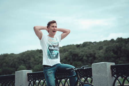 A man riding a bicycle in a park in cloudy weatherの写真素材