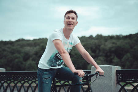 A man riding a bicycle in a park in cloudy weatherの写真素材