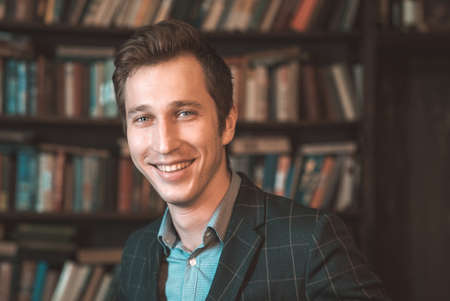 Portrait of a man in a jacket on the background of books