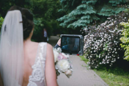 The bride is talking online on the tabletの写真素材