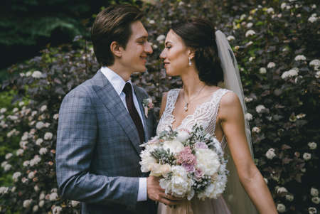 The bride and groom stand against the background of a flowering treeの写真素材