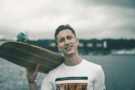 A man is riding a skateboard on a pier in a yacht club near the riverの写真素材