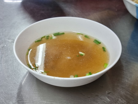 When we go to a noodle shop in Thailand and order dry type noodles, we get clear soup like this.の写真素材