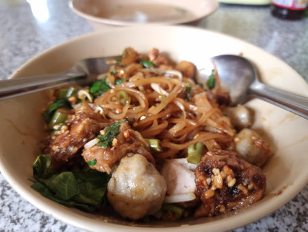 Savory Thai dry noodles with pork and meatballs. Authentic Asian street food. Perfect for food and travel visuals.の写真素材