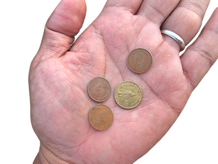 A close-up image of an open hand holding Thai coins, symbolizing finance, economy, savings, and...