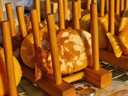 A close-up shot of a golden-brown, fish-shaped Taiyaki waffle maker with a waffle inside, displayed...