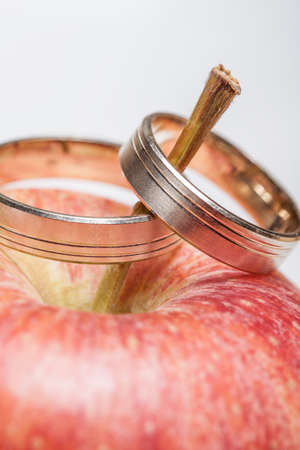 Wedding rings on the redappleの写真素材