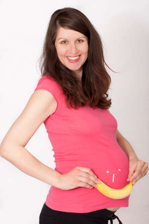 Smiling pregnant woman with banana smiling face