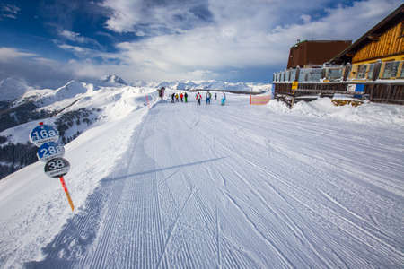 Skiers skiing in Kitzbuehel ski resort and enjoying Alps view from the top of Hahnenkamm, place of famous hahnenkamm races. Kitzbuehel ski resort is one of the best ski resort in the world with 54 cable cars and 170 km prepared skiing slopes, Tyrol, Austrのeditorial素材