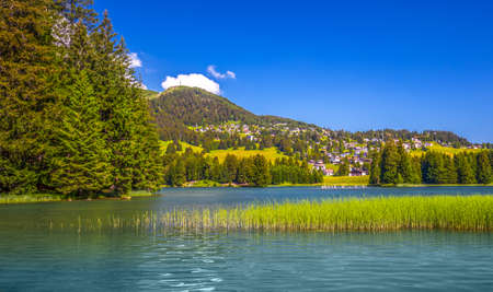 Panorama View to Lenzerheide village with Haidisee, Arose Rothorn and Swiss Alps. Lenzerheide is a mountain resort in canton Graubunden, Switzerland.の写真素材