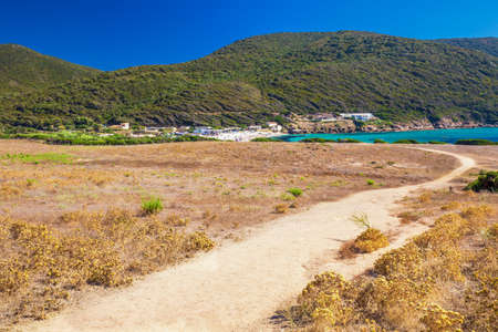 People enjoying the sunny weather on sandy Petit Capo beach with red rocks near Ajaccio, Corsica, Europe.の写真素材